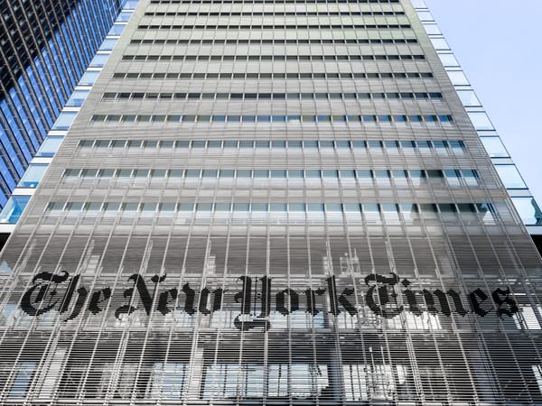 A picture from street level looking up at The New York Times building in Times Square with its logo prominent and center